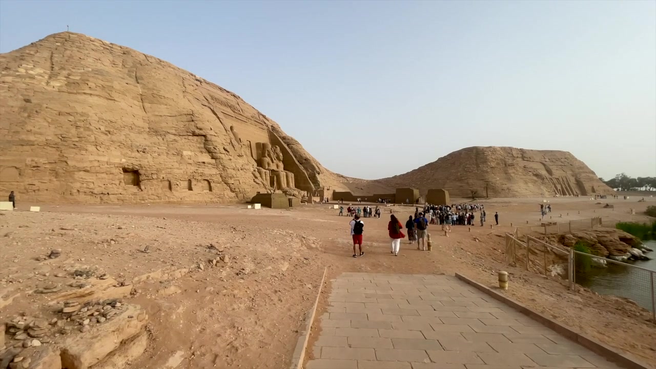 Punto di vista (POV) di avvicinamento al Tempio Egizio di Abu Simbel in Egitto. Templi di Ramses II e Nefertari in Nubia, Egitto. Camminando verso i monumenti nubiani dell'antica civiltà egizia. Turismo.