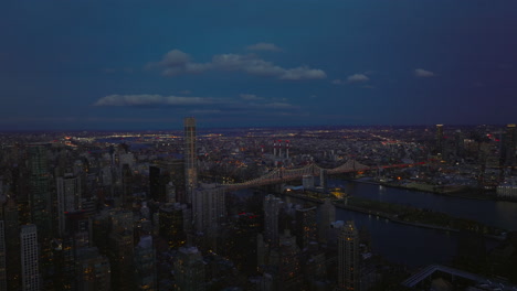 Aerial-panoramic-view-of-busy-Queensboro-Bridge-over-East-River.-Clouds-in-sky-over-evening-city.-Manhattan,-New-York-City,-USA