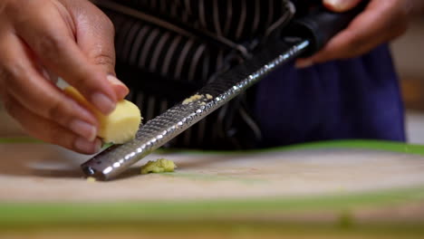 rallar o picar la raíz de jengibre para una receta casera - cámara lenta