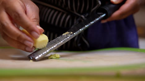 grating or mincing ginger root for a homemade recipe - slow motion