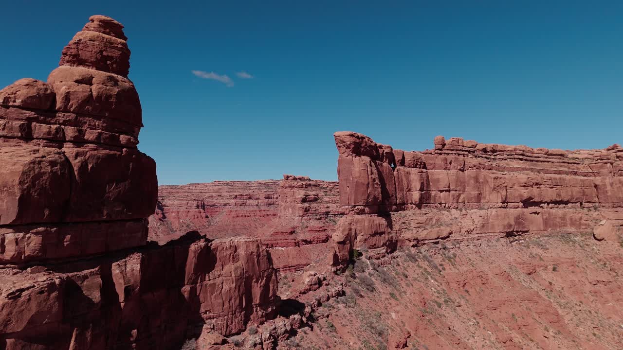 Ripresa aerea in allontanamento attraverso un'apertura nella parete rocciosa per rivelare la cresta nella Valle degli Dei nello Utah