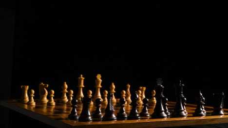 cinematic roll shot of chess pieces on a chessboard with a black background and a single light source coming from the right