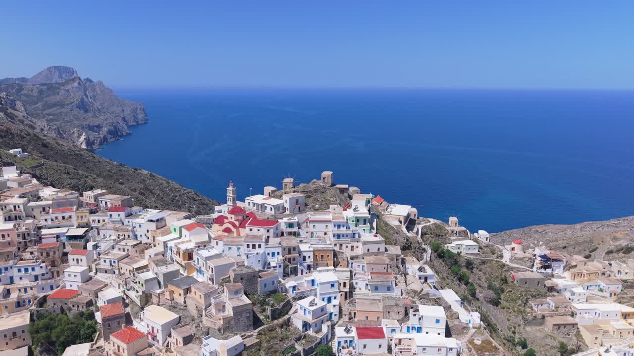 Drone footage revealing the landscape of Olympos Mountain in Karpathos and the namesake traditional village built on its hillside with beautiful Aegean surroundings