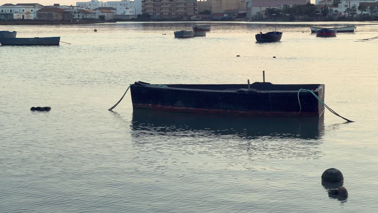Static view of a fishing boat without oars in a marina. Daylight
