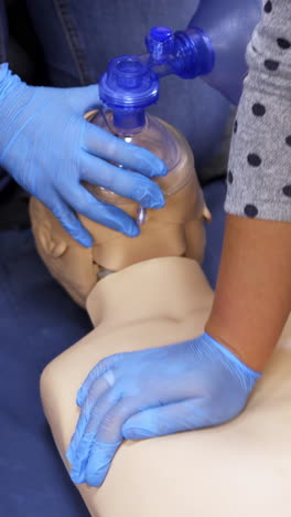 giving first aid on a mannequin. students teaching to do cardiopulmonology procedure on a dummy in training center. practical skills for saving people. top view. vertical video