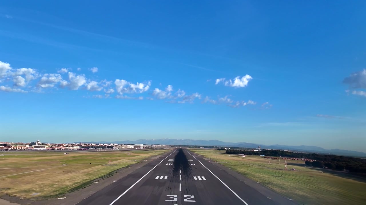 Sudut Pandang Pilot Imersif yang Direkam dari Dalam Kokpit Jet Selama Pendekatan Akhir ke Bandara Madrid pada Hari yang Cerah dengan Awan Tersebar di Langit Biru