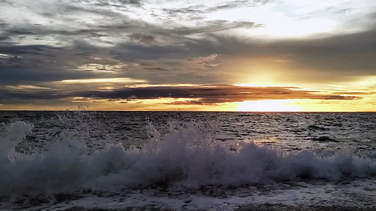 tranquila puesta de sol en las filipinas durante la hora dorada olas del océano graciosamente rodando en la playa, bahía de looc