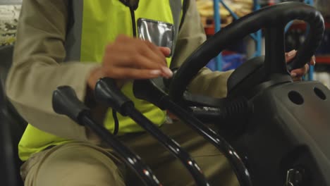 young female worker driving forklift in a warehouse