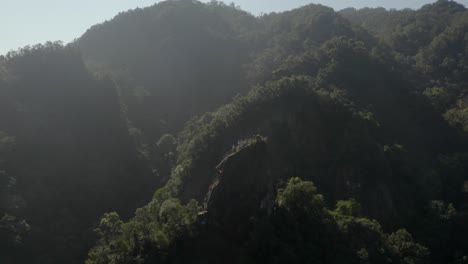 Gente-Haciendo-Turismo-En-El-Monte-Xiaozishan,-Senderos-Pingxi-En-Las-Montañas-Tropicales-Salvajes-De-Taiwán-Vista-Aérea-Hacia-Atrás