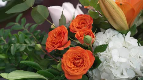 un ramo de rosas naranjas con hojas verdes