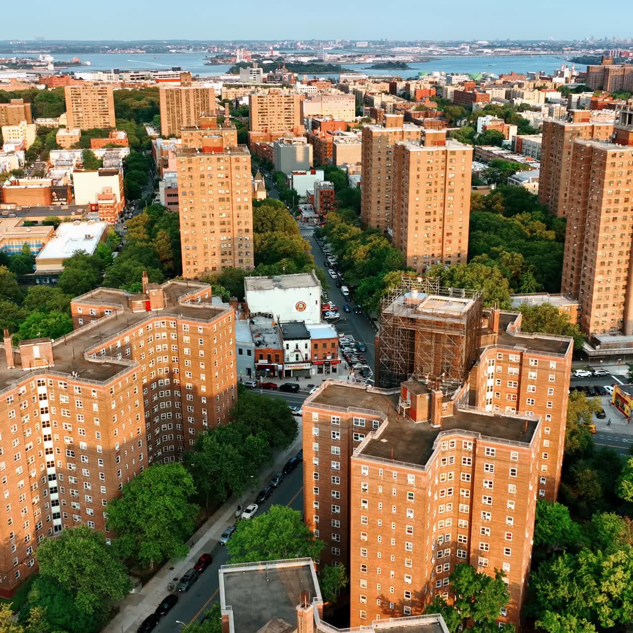 Beautiful neighborhood with plenty of greenery. Drone footage above the brick multi-storied buildings of New York at sunset