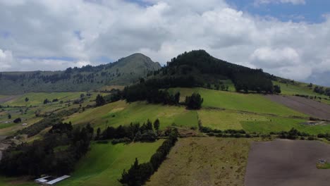 Toma-Aérea-De-Drones-Ascendentes-De-Granjas-Y-Picos-Montañosos-Boscosos.