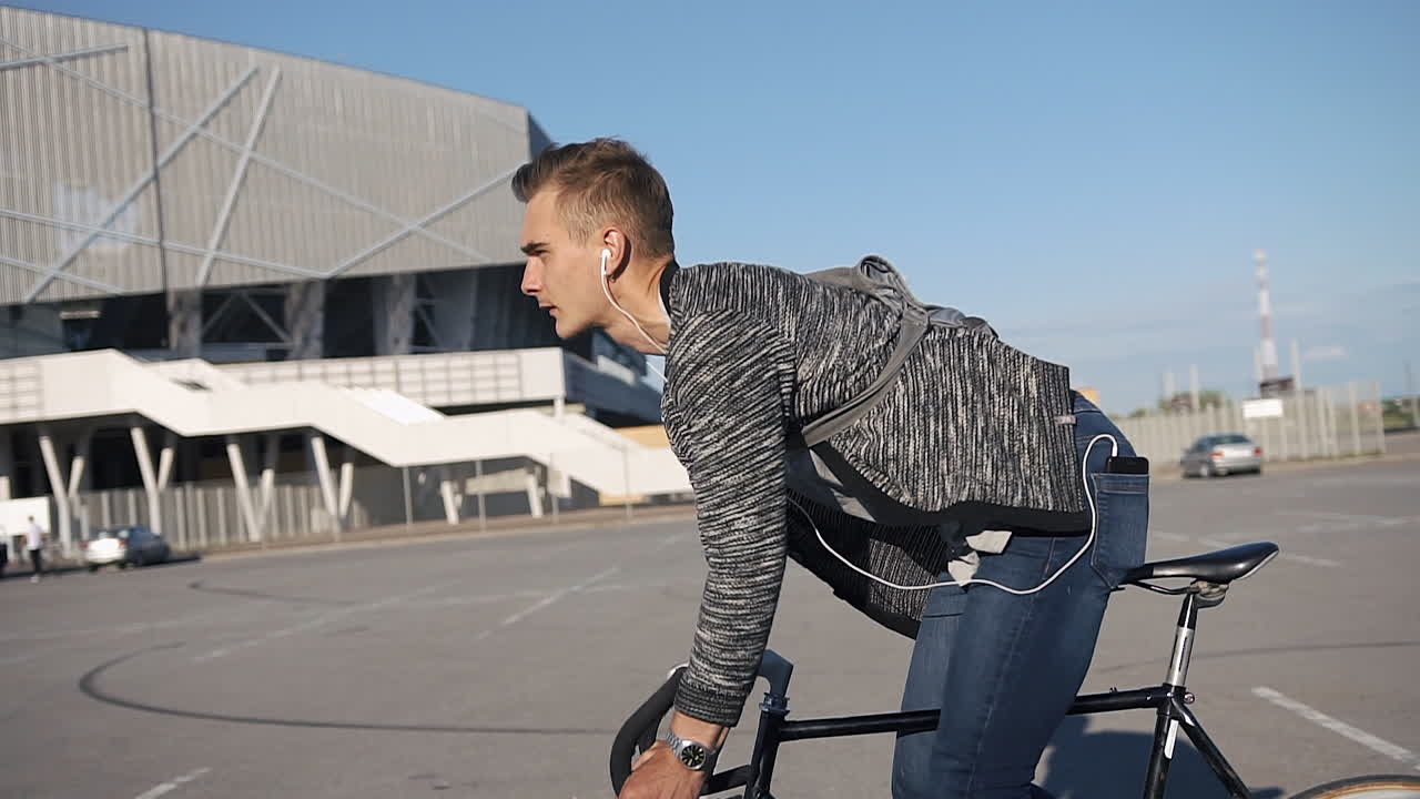 Man with Headphones Riding a Bicycle in the City