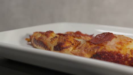 rebanadas de pizza girando en un plato en cámara lenta en un ambiente interior acogedor, su queso burbujeante y ingredientes vibrantes perfectamente exhibidos