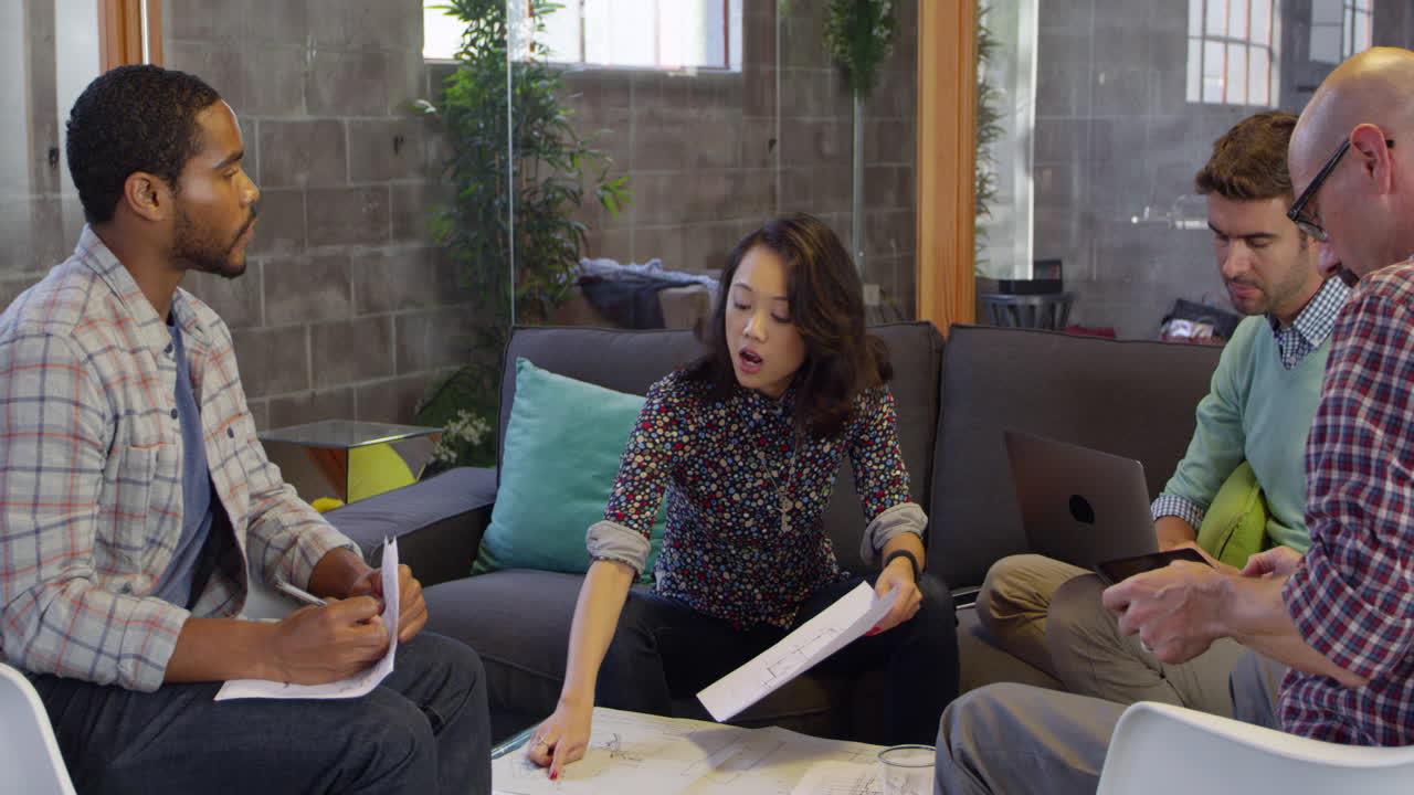 diseñadores que se reúnen alrededor de la mesa en la oficina filmado en r3d