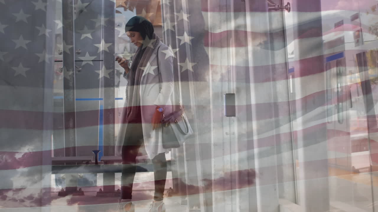 animación de la bandera estadounidense ondeando sobre una mujer biracial en hijab usando un teléfono inteligente