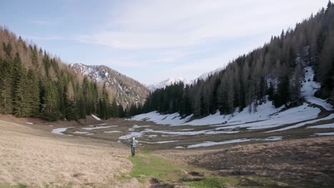 Walking-up-a-green-hiking-path-between-slovenia-and-austria-as-the-hiker-walk-towards-a-stationary-camera