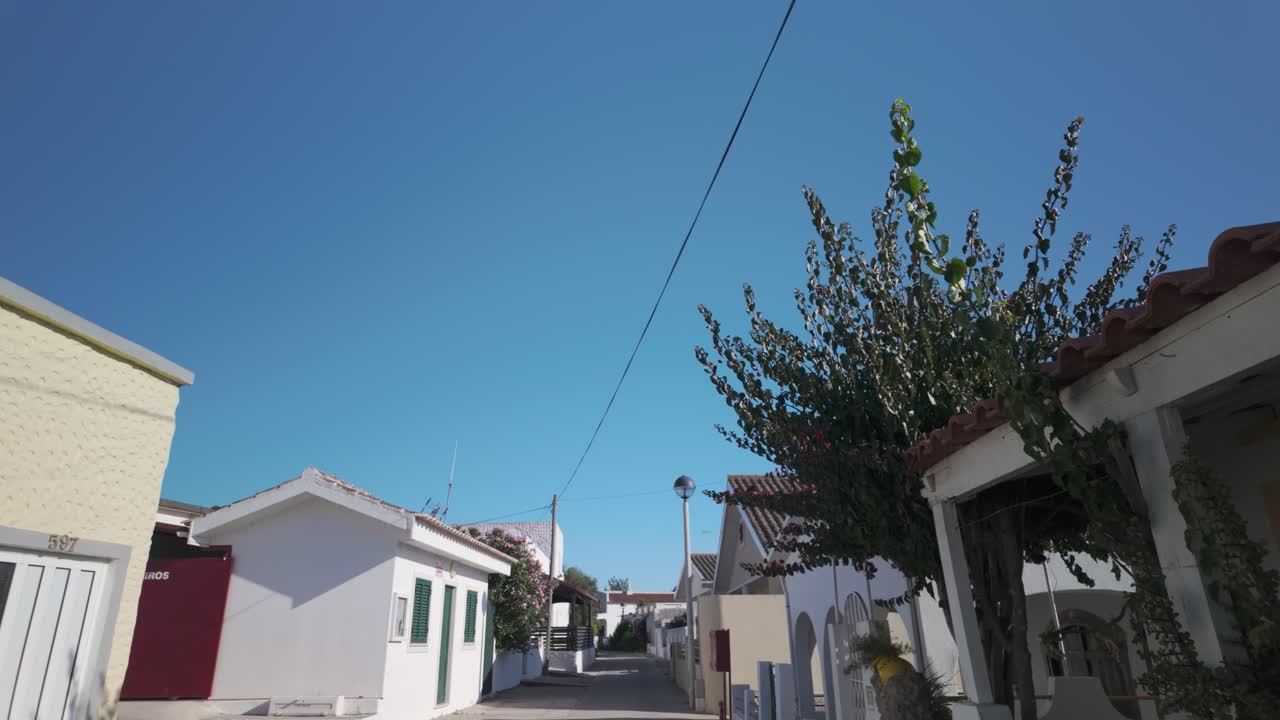 Traditional summer homes in Ilha da Armona Portugal along quiet paved alley