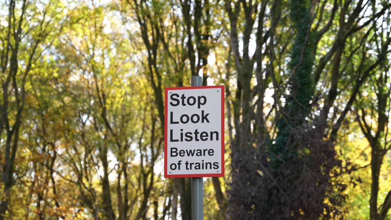 Stop Look Listen – Beware Trains. Safety sign at British railway crossing