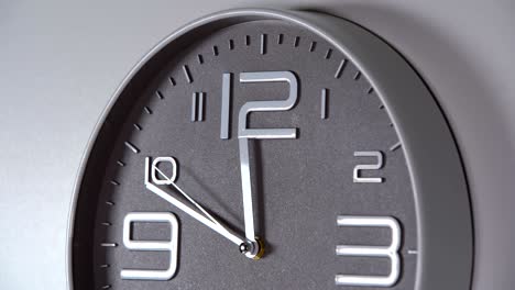 reloj de pared en un fondo gris. 23:50