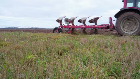 Agricultural-Tractor-Ploughing-The-Field-In-Latvia---low-level,-static-shot