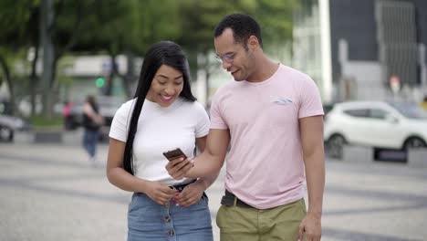 Front-view-of-happy-couple-walking-on-street-and-talking