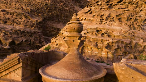 urn topped on conical roof of ad deir monastery during sunset in petra, jordan