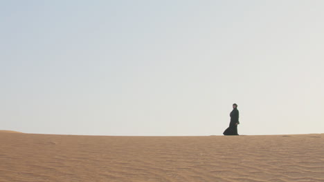 Mujer-Musulmana-Con-Hiyab-Caminando-Por-El-Desierto