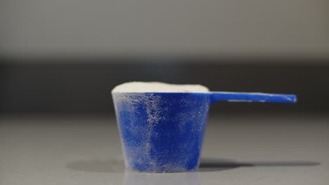 una cucharada de polvo de proteína de suero se coloca sobre la mesa