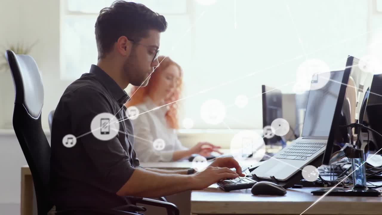 animación de una red de iconos digitales sobre un hombre caucásico pensativo usando una computadora portátil en la oficina.