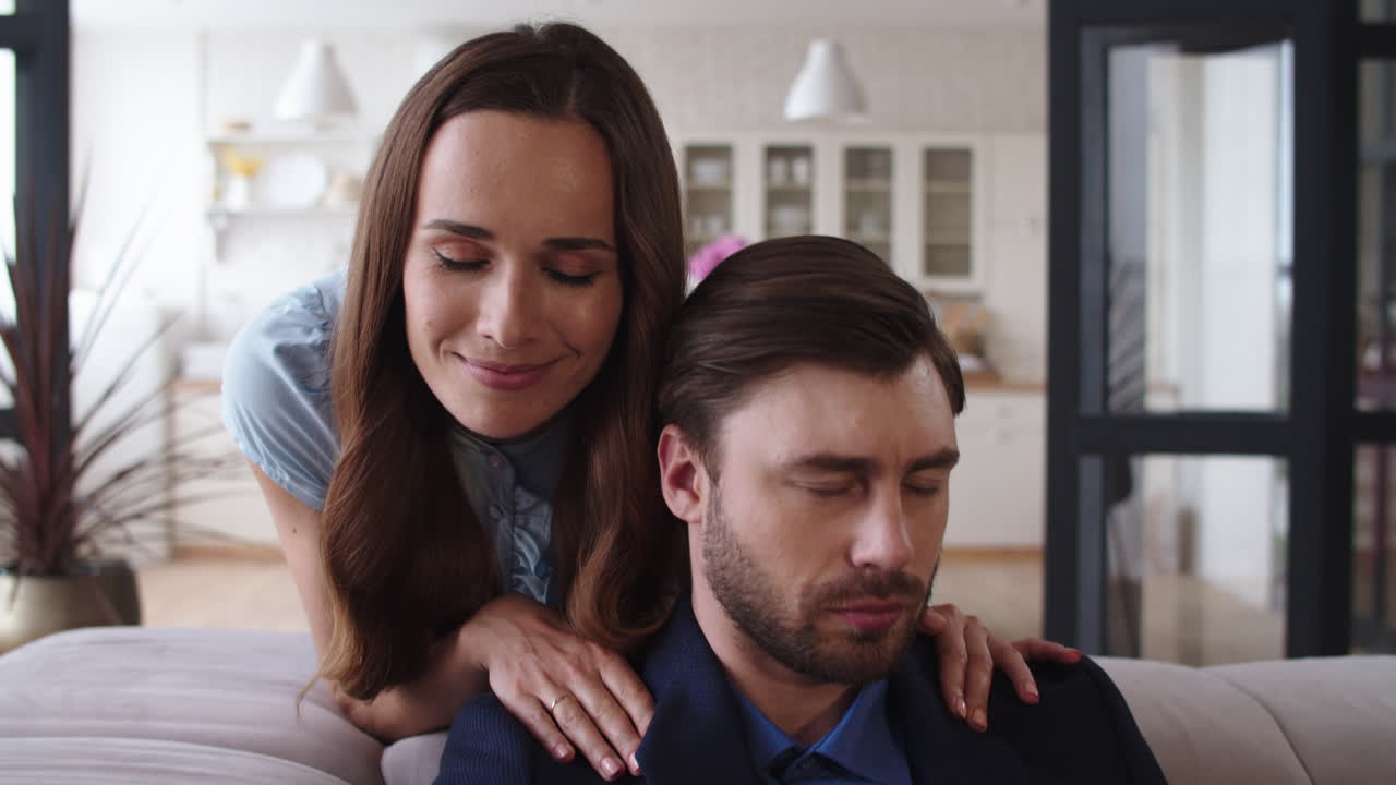 pareja feliz abrazándose en el sofá en la sala de estar