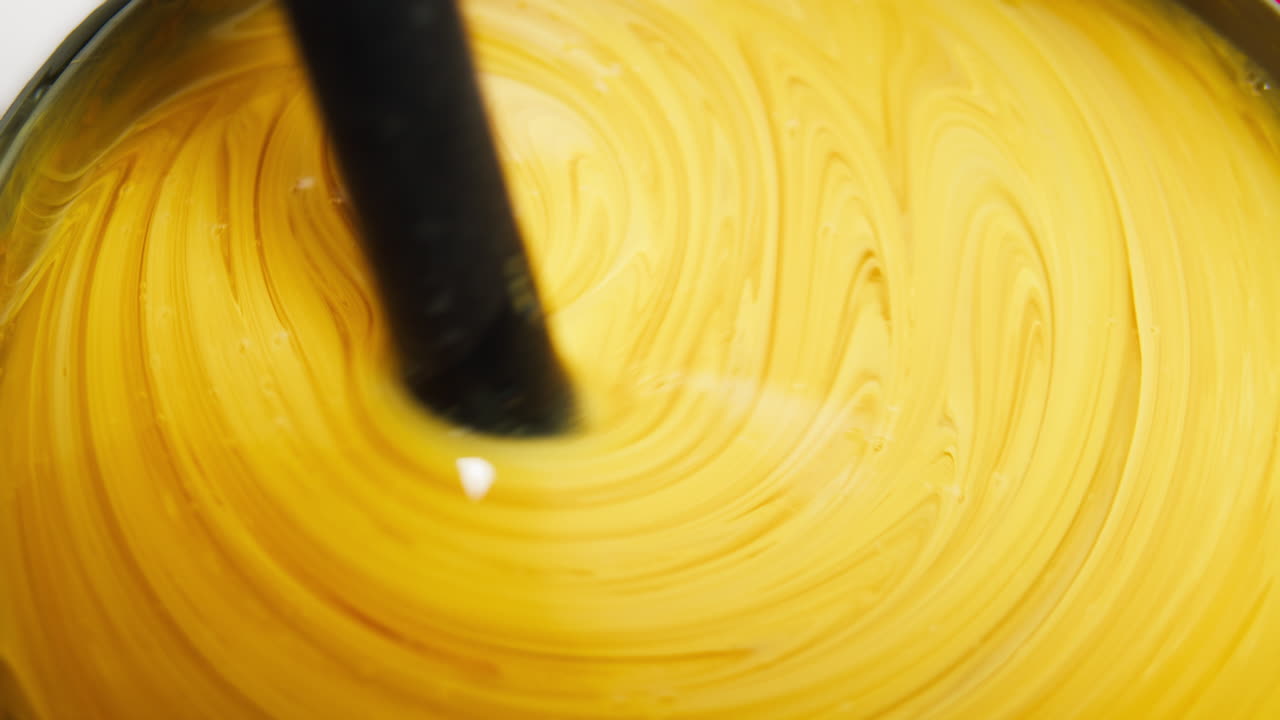 Primo piano di un liquido giallo brillante mescolato