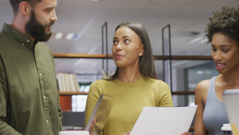 diversos colegas de negocios masculinos y femeninos hablando y sosteniendo documentos