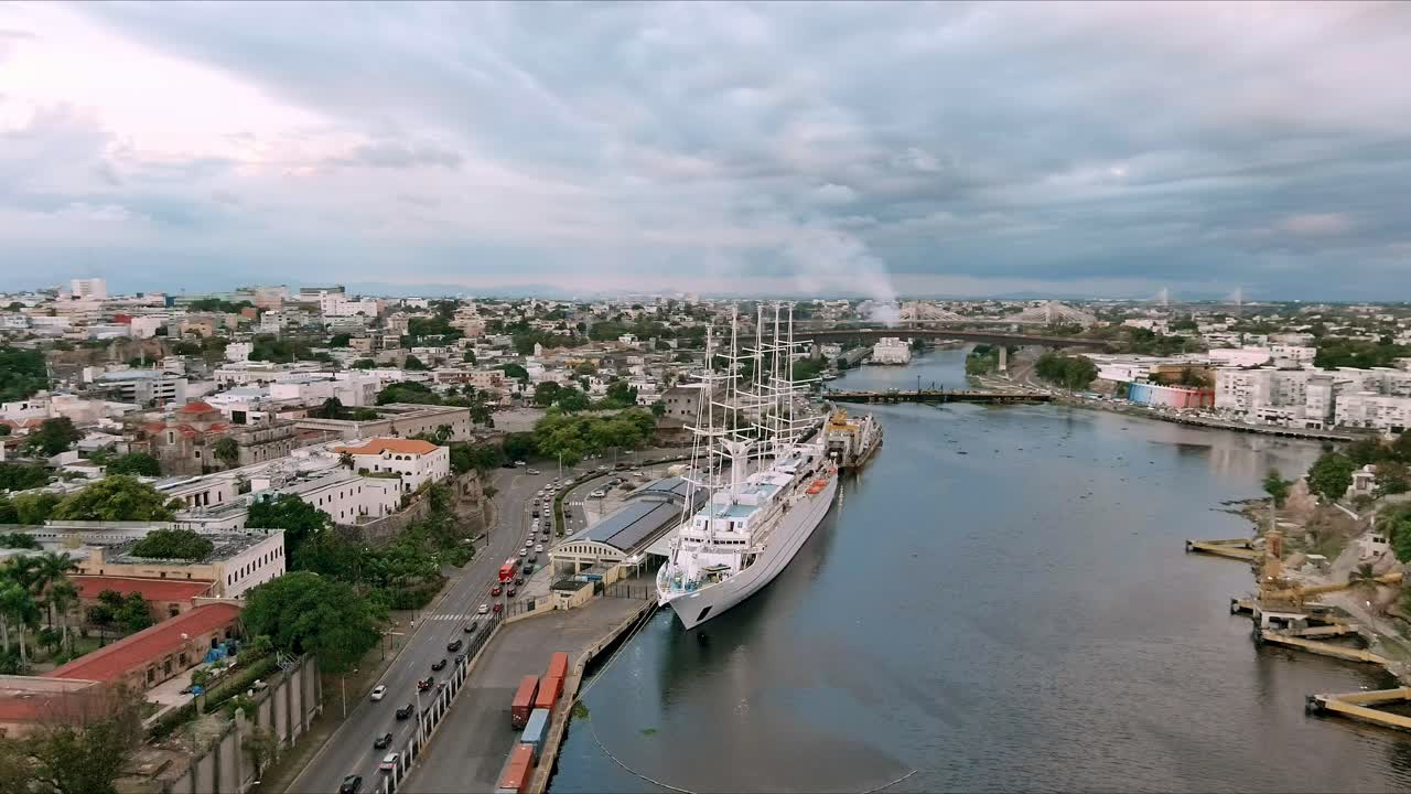 msy 바람 파도타기 배는 산토 도밍고 도시를 배경으로 일몰에 식민지 지역 항구에 정박해 있습니다.