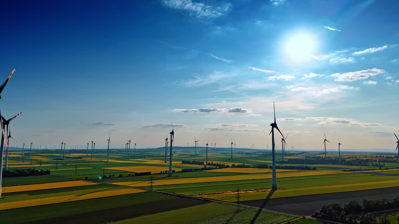 Beautiful green and yellow fields with wind mills. Renewable energy concept. Aerial view