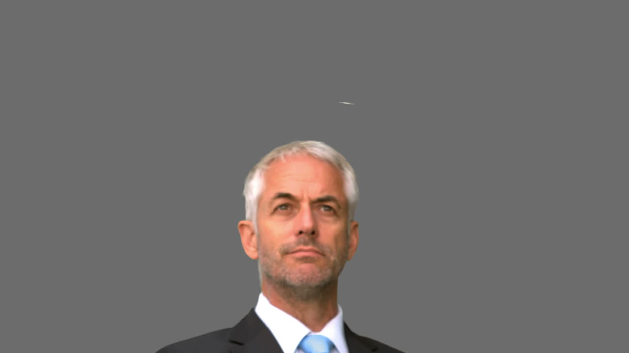 비즈니스맨이 회색 스크린에서 공중에 동전을 던지고 있습니다.