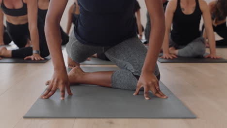 yoga class instructor teaching group of young women sleeping pigeon pose on exercise mat enjoying healthy lifestyle training meditation practice in fitness studio