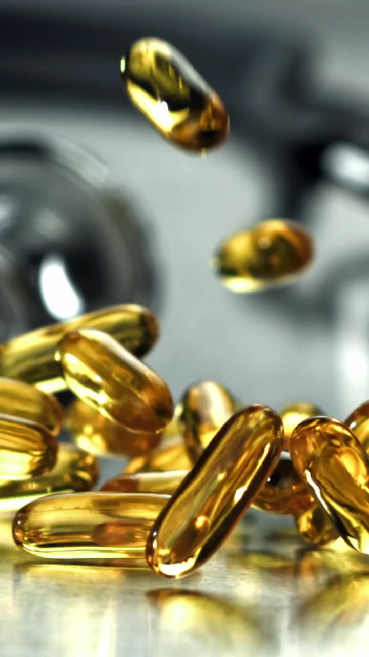 Golden Omega 3 Softgel Capsules Falling in Slow Motion