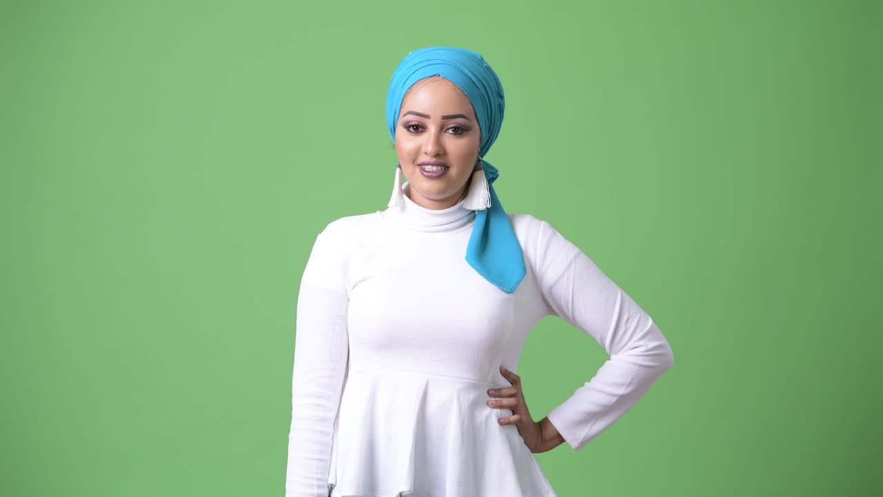 Young beautiful African Muslim woman against chroma key with green background