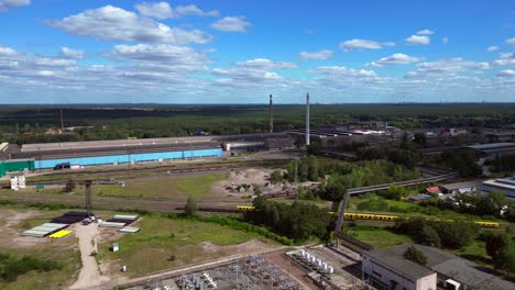 hennigsdorf substation, distributing electricity and surrounded by a lush green forest in brandenburg, germany. great aerial view flight descending drone