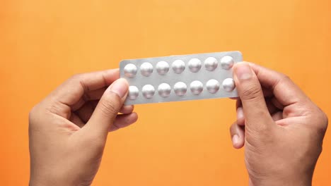 hands holding a blister pack of pills