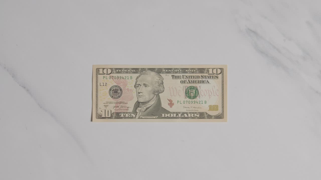 마블 표면에 10 달러 지폐를 잡는 손의 상공 통화  ⁇