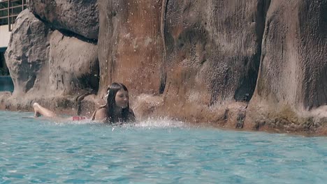 young brunette in bikini spends time in pool slow motion