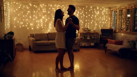 couple dancing at home with christmas lights