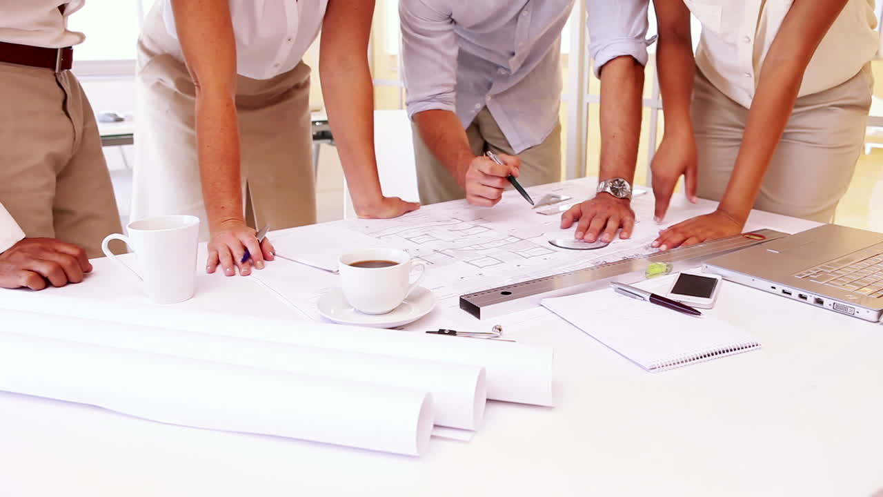 equipo de arquitectos revisando los planos