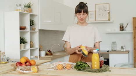 Woman-Taking-off-Groceries-from-Bags-in-Kitchen