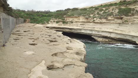 St-Peter’s-Pool-Stone-Beach-Cave-with-Nobody-Around-Just-Some-Scarce-Greenery-on-Hill