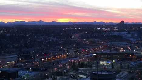 Cityscape-at-dusk-with-mountains-on-horizon