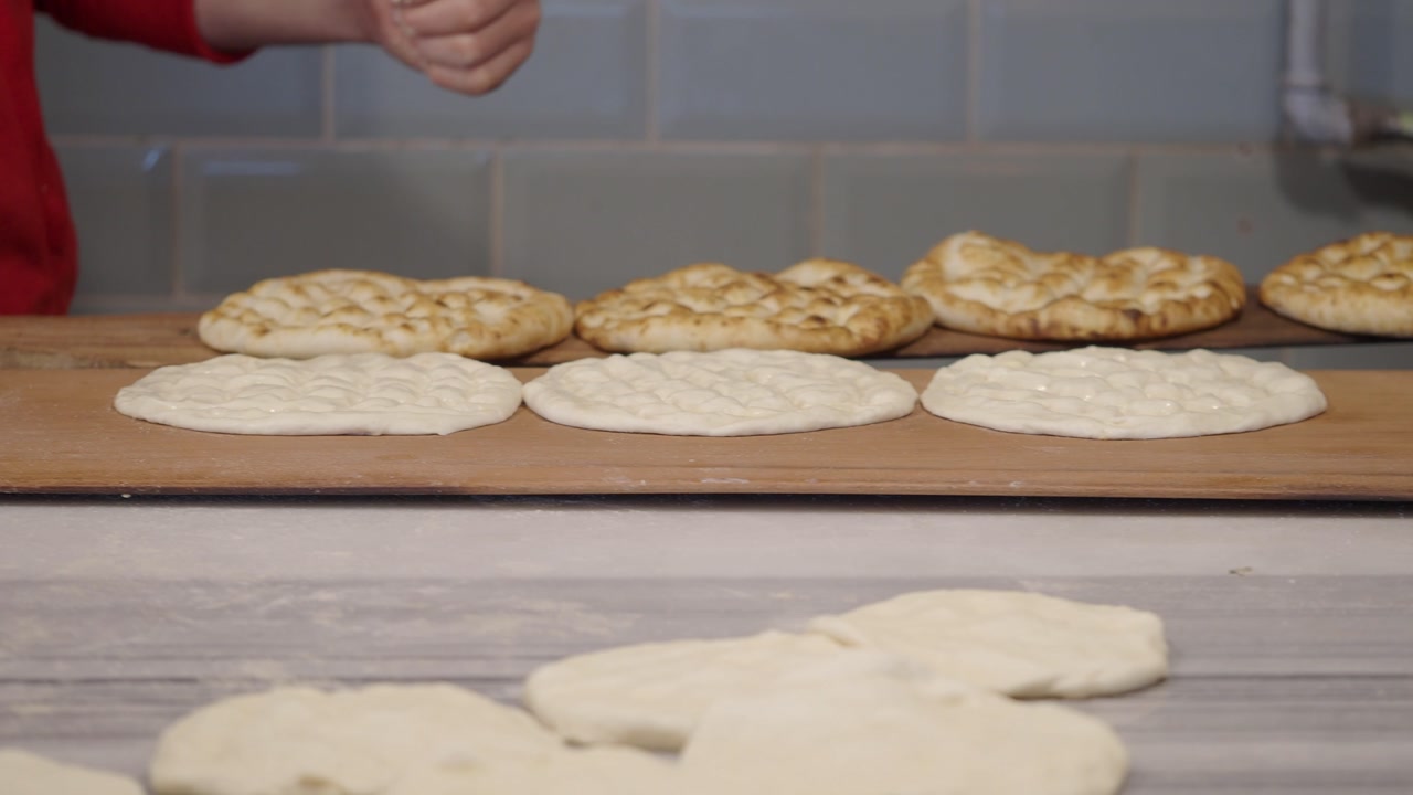 Baker Stacking Freshly Baked Flatbreads