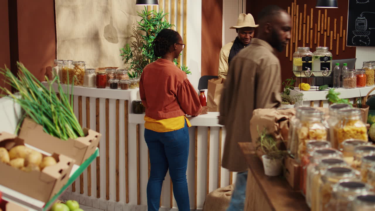 mujer de saludo de comerciante en la caja de la tienda ecológica de cero residuos